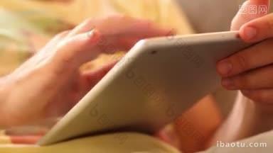 一个男人用他的ipad<strong>上网</strong>，两只手碰着平板电脑屏幕浏览
